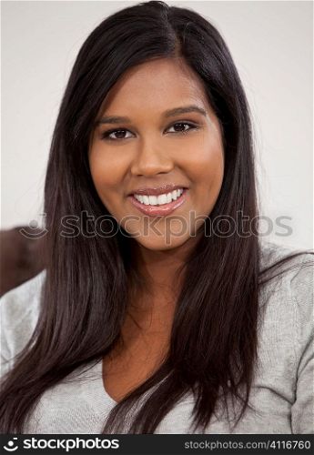 A beautiful young Indian Asian woman with a perfect toothy smile.