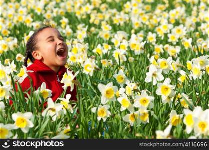 A beautiful young mixed race girl playing in a field of daffodils
