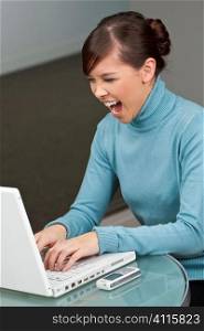 A beautiful young oriental woman getting angry with her laptop.