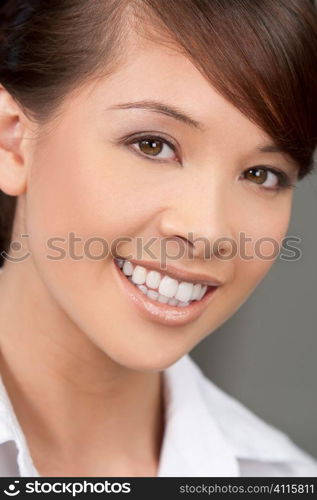 A beautiful young oriental woman with a wonderful toothy smile