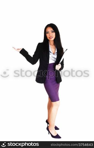 A beautiful young slim Asian business woman in a black jacked andlilac skirt with long black hair standing for white background.