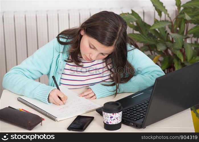 a beautiful young teenager girl doing her homework