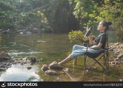 A beautiful young traveler woman is enjoying with nature drinking coffee in the morning over lake, relaxation , c&ing holiday and travel concept . . Beautiful young traveler woman is enjoying with nature drinking coffee in the morning over lake, relaxation , c&ing holiday and travel concept . 