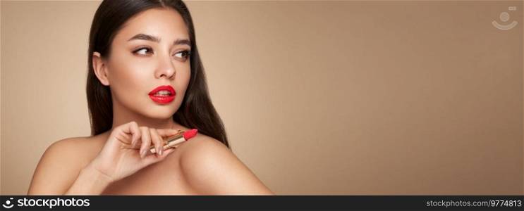 A beautiful young woman applying lipstick. Model with healthy skin, close up portrait. Cosmetology, beauty and spa