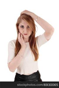 A beautiful young woman in a beige sweater and long brunette hairholding her hands on her face, isolated for white background