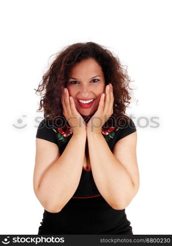 A beautiful young woman in a black dress is happy and holding her&#xA;hands on her face, isolated for white background.&#xA;