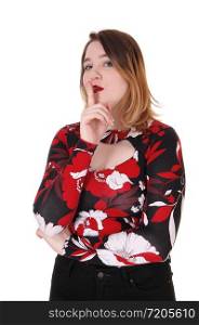 A beautiful young woman in a colorful blouse and blond hair standing with one finger over her mouths, be quiet, isolated for white background