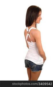 A beautiful young woman in a shorts and white top standing in the studio from the back, for white background.