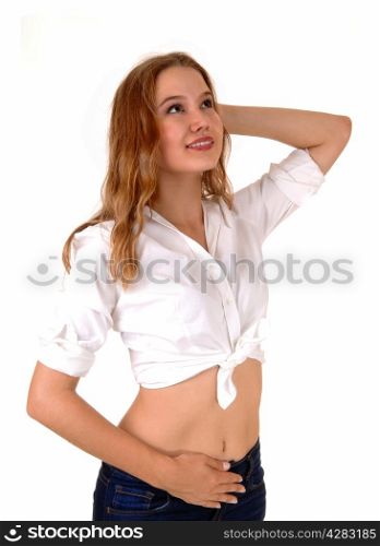 A beautiful young woman in a white blouse and jeans standingisolated for white background, looking up.