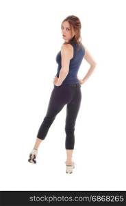 A beautiful young woman in an exercising outfit standing over whitebackground from the back with her hands on her hips
