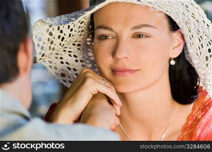 A beautiful young woman looking lovingly across a table at her man.