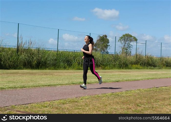 A beautiful young woman making some exercise at the park - fitness concept