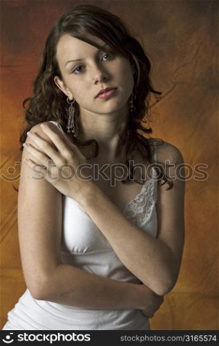 A beautiful young woman poses against a canvas background