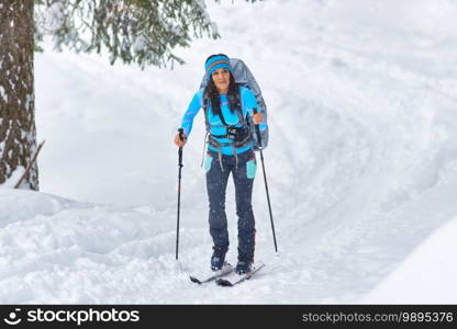 A beautiful young woman practicing hiking skiing alone