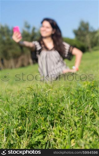 A beautiful young woman relaxing at the city park - Selective focus on the grass