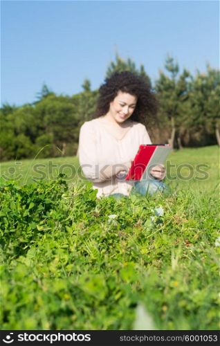 A beautiful young woman relaxing at the city park - Selective focus on the grass