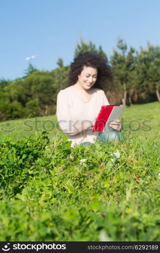 A beautiful young woman relaxing at the city park - Selective focus on the grass