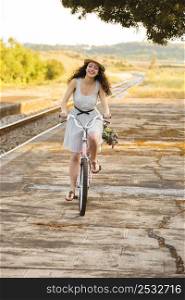 A beautiful young woman riding her bicycle