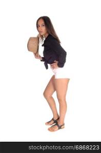 A beautiful young woman standing in profile in shorts, holding acowboy hat in her hand, isolated for white background