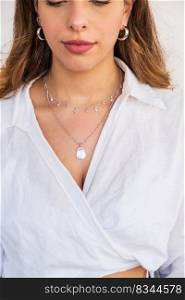 A beautiful young woman wearing silver clear and pearl necklaces and silver earrings. Beautiful valentine&rsquo;s gifts.