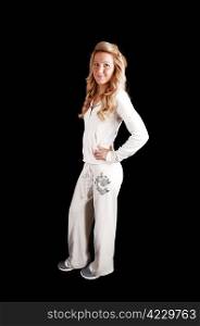 A beautiful young woman with long curly blond hair in a white track suitstanding in the studio for black background.
