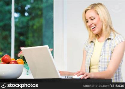 A beautiful young woman working from home on her laptop computer