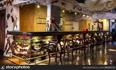 A beautifully decorated empty bar with a colorful counter and bar stools