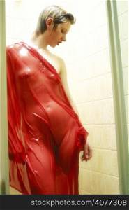 A beauty shot of a young 20s woman in red drapery, her body is wet and the drapery clings to the shape of her figure.