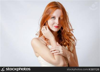 A beauty shot of a young blue eyed woman with her red hair