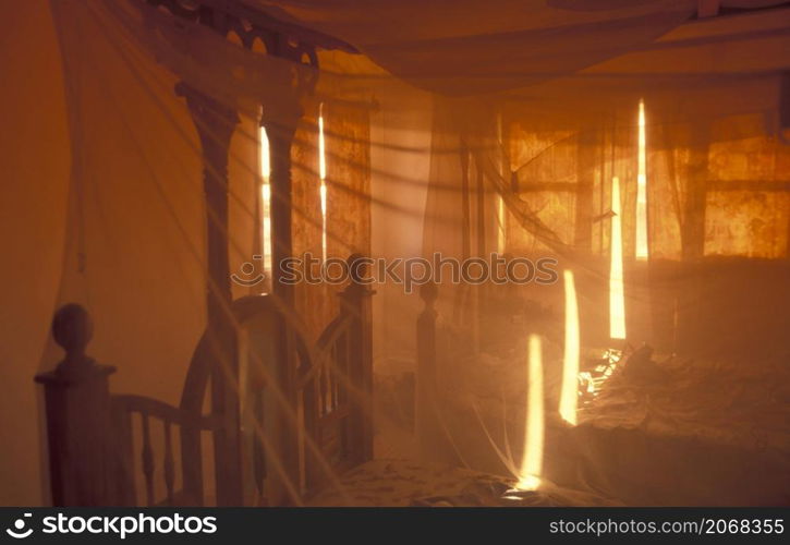 a Bed with mosquito net in a room in a Guesthouse in the Old Town of Stone Town on the Island of Zanzibar in Tanzania. Tanzania, Zanzibar, Stone Town, October, 2004