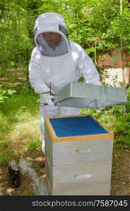 a beekeeper is opening hive