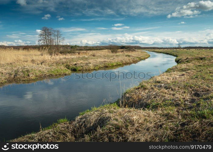 A bend in the calm river and clouds on the sky, spring view