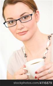 A beuatiful young female woman enjoying a cup of tea/coffee