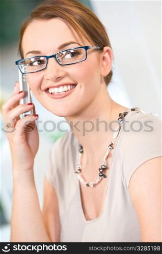 A beuatiful young woman happily chatting on her mobile phone