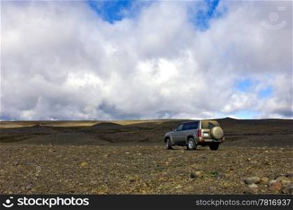 A big four by four all terrain car in the vastness of the Icelandic tundra
