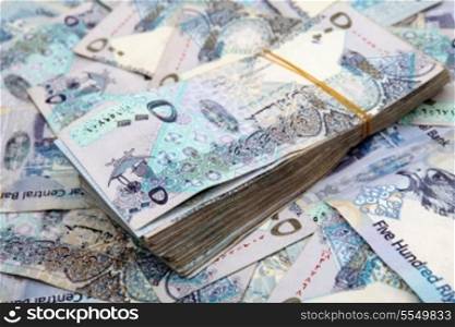 A big pile of very high-value Qatari banknotes, each one worth about $150 or ?100.