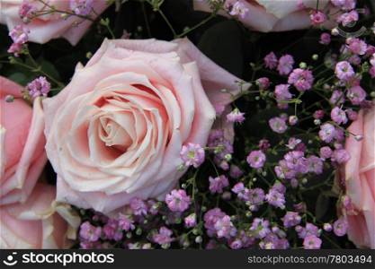 A big pink rose and purple gypsophila in a flower arrangement