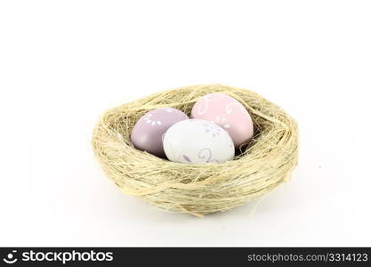 A bird nest with colored eggs isolated on white