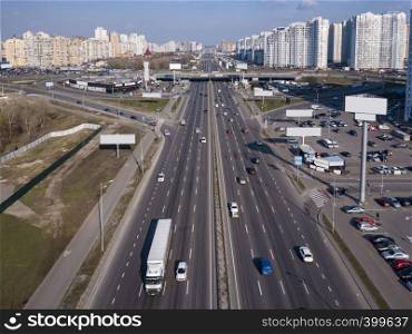 A bird's eye aerial view from drone to the Kharkivskiy district of Kiev, Ukraine with highway, road junction and modern buildings.. Panoramic aerial view from drone Pozniaky district, Mykoly Bazhana Ave with traffic and modern building of the city Kiev Ukraine.
