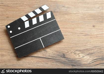 A black and white movie board on a wooden background