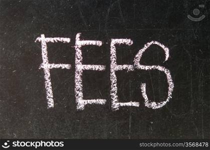 A black board with a wooden frame and the word &rsquo;FEES&rsquo; written in chalk.