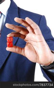 A black businessman holding two red dice in his hand, in a blue suitstanding isolated for white background.