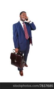 A black businessman standing isolated for white background talking onthe cell phone whit a briefcase in his hand.