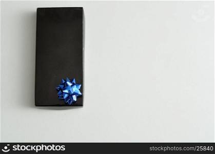 A black gift box with a blue bow isolated on a white background