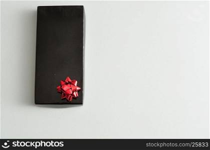 A black gift box with a red bow isolated on a white background