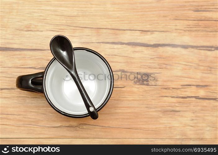 A black mug with a black teaspoon