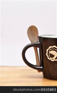 A black mug with a brown teaspoon