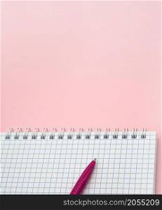 A blank checkered sheet of paper. Notepad and pen on pink. Pink Pen. Notepad spring Spiral spiral checked sheets.. Notepad and pen on pink. Pink Pen. A blank checkered sheet of paper. Notepad spring Spiral spiral checked sheets.