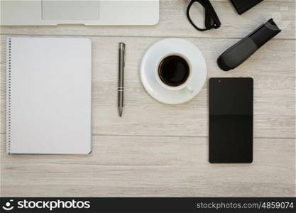 A blank notebook with a pencil and a cofee on a grey wooden background