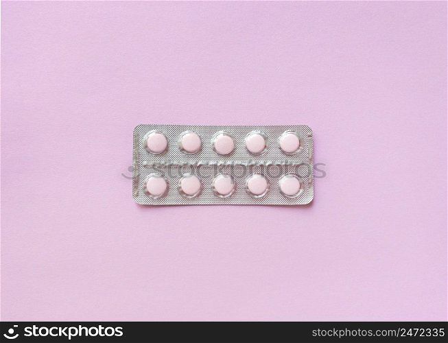 A blister of soft pink pills in the middle on pink background. Monochrome simple flat lay with pastel texture. Medical concept. Stock photography.. A blister of soft pink pills in the middle on pink background. Monochrome simple flat lay with pastel texture. Medical concept. Stock photo.
